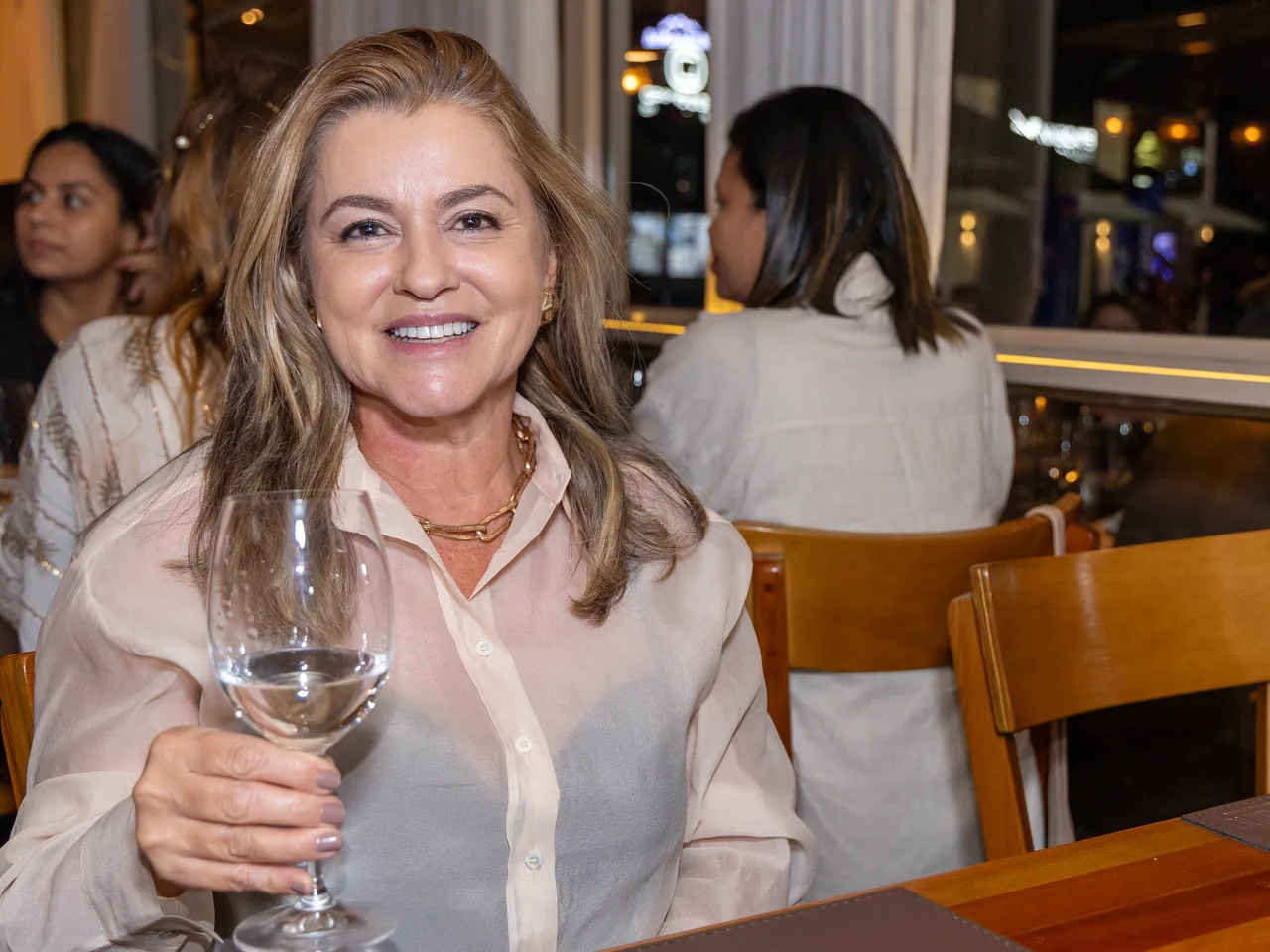 Convidada com taça de vinho no salão